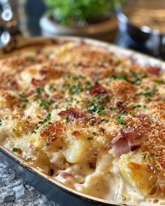 a casserole dish with ham and cheese in a black pan on a table