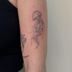 a woman's arm with a jellyfish tattoo on the left side of her arm