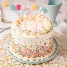 a birthday cake with white frosting and multicolored sprinkles