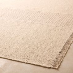 a white rug with fringes on the floor