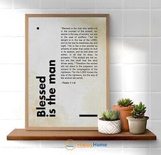 a wooden shelf with two potted plants next to a framed poster on the wall