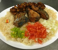 a white plate topped with rice, meat and veggies on top of it