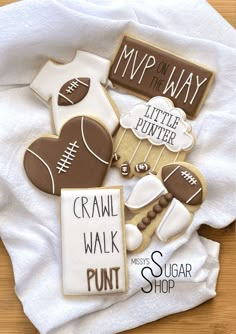 some cookies are laying on top of a white shirt and the cookie is decorated like footballs