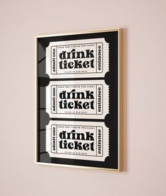 three tickets are hanging on the wall in front of a pink wall with black and white lettering