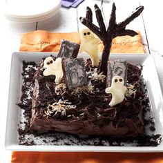 a square cake decorated with chocolate frosting and spooky ghost decorations