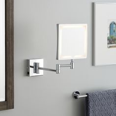 a bathroom with a mirror, towel rack and two lights on the wall above it