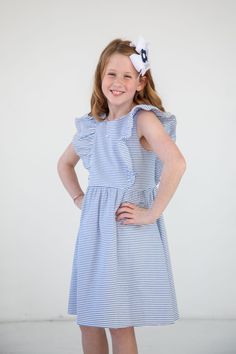 From our Later Gator collection: 100% cotton royal and white stripe seersucker Waistline silhouette with shirred skirt Front shirred ruffles Back zipper Above knee length Machine washable Coordinating stripe seersucker baby sister romper style C4450 and little sister dress style C4451 Spring Striped Dresses With Ruffles, Cute Seersucker Dresses With Ruffles, Cute Ruffled Seersucker Dresses, Summer Ruffle Dress In Lightweight Fabric, Striped Dress With Ruffle Sleeves For Spring, Striped Summer Dress With Ruffle Hem, Spring Seersucker Dress With Ruffles, Striped Seersucker Dresses With Ruffles, Striped Sleeveless Seersucker Dress