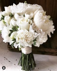 a bouquet of white flowers sitting on top of a table