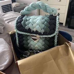 a handbag sitting in a box on top of a bed