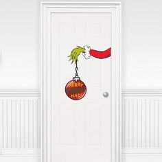 the grinch door sticker is hanging on a white door with a santa hat