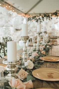 a long table with candles and plates on it