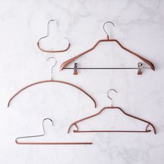 two wooden clothes hangers sitting on top of a marble counter