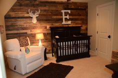 a baby's room with a deer head on the wall and a white crib