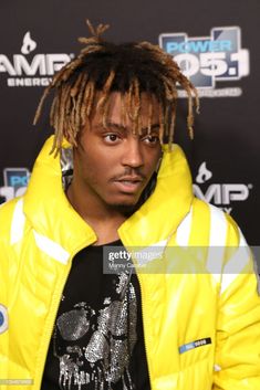 young man with dreadlocks wearing yellow jacket and black t - shirt at an event