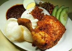 a white plate topped with fried chicken, mashed potatoes and cucumbers