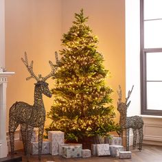 the christmas tree is decorated with deer and presents