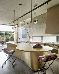 a kitchen with an island and chairs in it