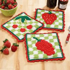 three crocheted placemats with strawberries and cherries on the table