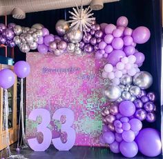 balloons and streamers decorate the backdrop for a 35th birthday party in purple, silver and white