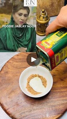 a person pouring something into a white bowl on top of a wooden table next to pictures