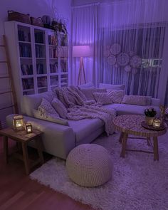 a living room filled with furniture and purple lighting