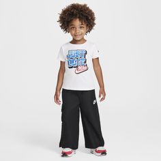 Your child can step up their game in this 2-piece set, designed with functionality in mind. The graphic tee is made of soft cotton/poly jersey in a roomy cut with a tagless crewneck for easy wear. The matching straight leg pants are made of woven poly twill boosted with quick-drying, moisture-wicking Dri-FIT technology to help them stay cool and dry while they play. The stretch waistband provides a comfy fit, a spacious cargo pocket with hook-and-loop closure flaps can help secure small items and venting at the cuffs make it easy for kiddos to move freely. Sporty Graphic Print Sets For Playwear, Sporty Graphic Print Playwear Set, Sporty Graphic Print Sets For Sports, Sporty Playwear Set With Graphic Print, Sporty Graphic Print Sports Sets, Nike Sets With Graphic Print And Crew Neck, Nike Crew Neck Sets With Graphic Print, Nike Graphic Print Crew Neck Sets, Nike Sets With Letter Print And Short Sleeve