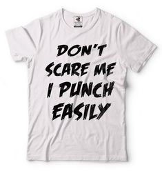 "Halloween Costume T-Shirt Funny Halloween Party Don't Scare Me I Punch Easily Cool Graphic Halloween Tee Shirt This ULTRA COTTON UNISEX T-shirt is made of Pre-shrunk 100% cotton, 6.1-ounce. * Seamless double-needle 7/8\" collar, Double-needle sleeves and hem, Taped neck and shoulders Our T Shirts and Hoodies are Printed by advanced technology Digital Printer on 100% Ultra Cotton tees and hoodies . We use waterbased textile ink, Safest ink type for everyone. Each T shirt is Made individually and Halloween Slogan T-shirt For Streetwear, Punk Halloween T-shirt With Text Print, Punk Halloween Text Print T-shirt, Halloween Costume Funny, Halloween Tee Shirts, Unique Gifts For Dad, Ladies Shirt, Digital Printer, Costume Shirts