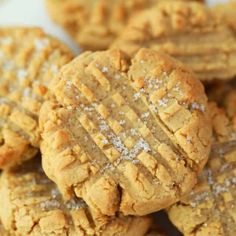 a pile of peanut butter cookies with powdered sugar on top and one cookie in the middle