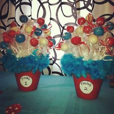 two red buckets filled with candy and candies on top of a blue table