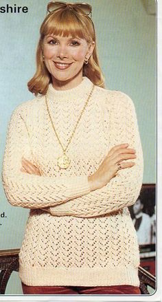 a woman wearing a white sweater with her arms crossed