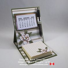 a desk calendar with flowers on it and a notepad in the holder for writing