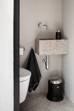 a white toilet sitting next to a sink in a bathroom