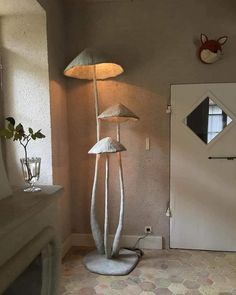 a lamp that is on top of a stand in the middle of a room next to a door