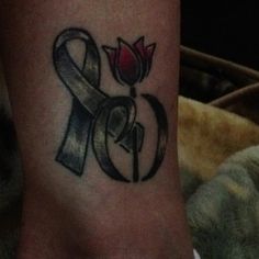 a tattoo on the foot of a person with a rose and ribbon around it's ankles