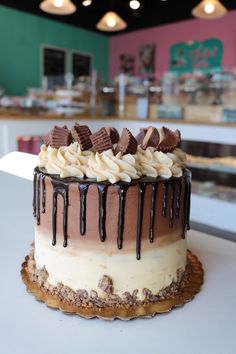 there is a cake with chocolate and cream icing on the table in a bakery