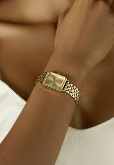 a close up of a person wearing a watch on their wrist and holding her hand to her face