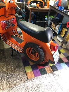 an orange scooter is parked in a garage