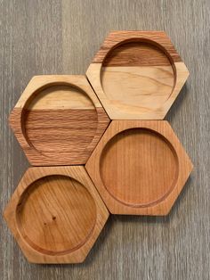 four wooden plates arranged in the shape of hexagons on top of a table