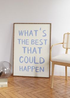 a white chair sitting next to a poster on top of a hard wood floor in a room