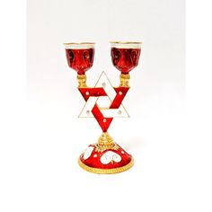 two red glass candlesticks sitting on top of each other with a star of david in the middle