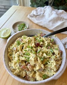 a bowl filled with food sitting on top of a table next to a lime slice