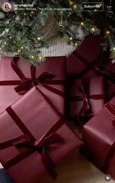 several wrapped presents sitting next to a christmas tree