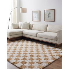 a living room with a couch, rug and pictures on the wall