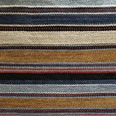 multicolored striped rug with different colors and patterns on the carpet, close up