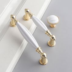 two white and gold handles on the door knobs, one with an oval handle