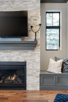 a fireplace with a flat screen tv mounted on it's wall above the fire place