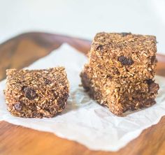 two pieces of granola sitting on top of a wooden table next to each other