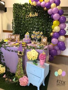 a purple and yellow dessert table with balloons