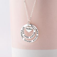 "This 100% Sterling Silver necklace is a meaningful and sweet gift for grandma, with her being in the centre on a heart charm and grandkids' names surrounding her. A perfect gift for Grandma on any occasion. PRODUCT INFO * Materials: 925 sterling silver with 18K yellow gold or rose gold plated options.  * Small ring measures approx. 3/4\" (20mm). Big ring measures approx. 1\" (26mm). Heart charm approx. 0.37\" x 0.32\" (9.8 x 8.5mm) * WORD LIMIT: Small ring: 4-5 words / Big ring: 6 words. Date is counted as 2 words. * By default, silver charm comes with BLACK engraving and gold-plated charm comes with CLEAR engraving HOW TO ORDER * Select your preferred finishing color, number of the rings and necklace length from the menu. * Include in the \"Add your personalization\" box the names on eac Mother's Day Birthday Name Necklaces, Name Necklaces For Birthday And Mother's Day, Silver Birthday Name Necklace With Heart Charm, Heart Pendant Charm Necklace For Birthday And Mother's Day, Heart-shaped Hallmark Name Necklace For Birthday, Names Charm Necklaces For Birthday And Valentine's Day, Name Charm Necklace With Heart Pendant For Birthday, Birthday And Valentine's Day Charm Necklaces With Names, Name Charm Necklaces For Birthday On Valentine's Day