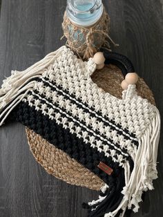 a black and white bag sitting on top of a wooden floor next to a bottle